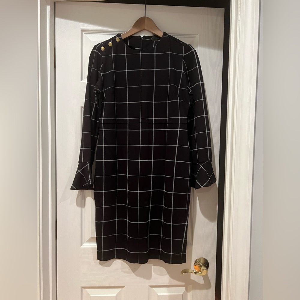 Iman long sleeved dress with fluted sleeves. Black with a white plaid pattern.